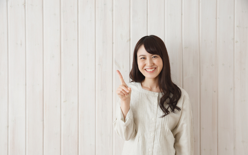 秋のお家デートで気をつけたい服装のポイントを指差しながら説明する女性のイメージ。清潔感と親しみやすさを演出。